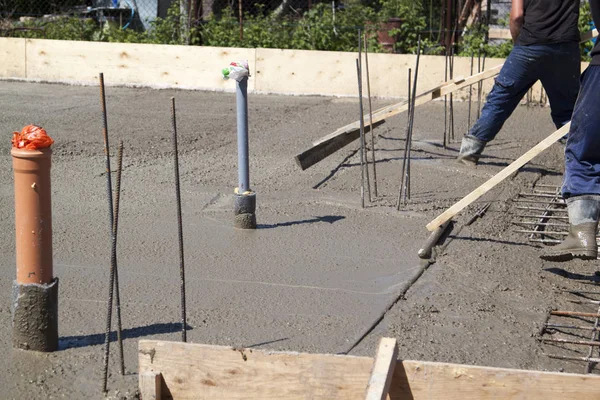 Worker leveling fresh concrete slab with a special working tool — Stock Photo, Image