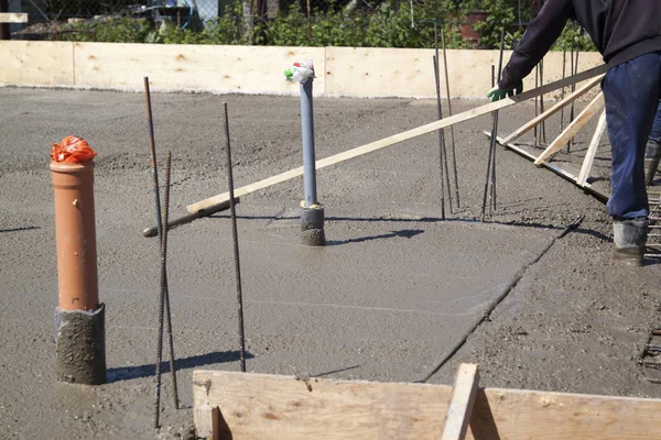 Twee werknemers nivelleren verse betonnen plaat met een speciale werk — Stockfoto