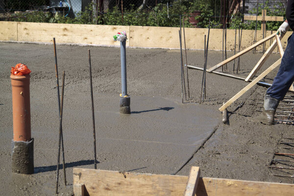 два рабочих в резиновых сапогах стоят в незагроможденном цементе и леве
