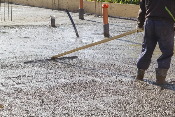 Trabalhador nivelamento laje de concreto fresco com uma ferramenta de trabalho especial — Fotografia de Stock