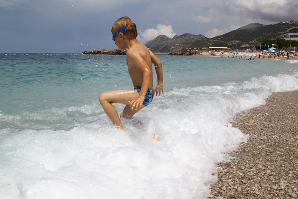 Kinder spielen mit den Wellen des Meeres — Stockfoto
