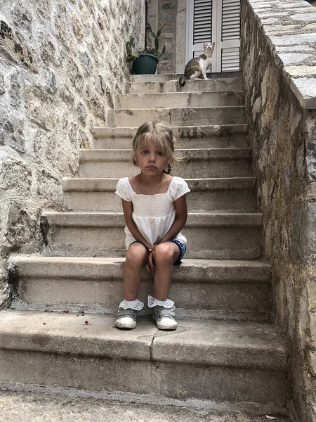 Modesta triste bambina seduta sulle scale di pietra nel mediev — Foto Stock