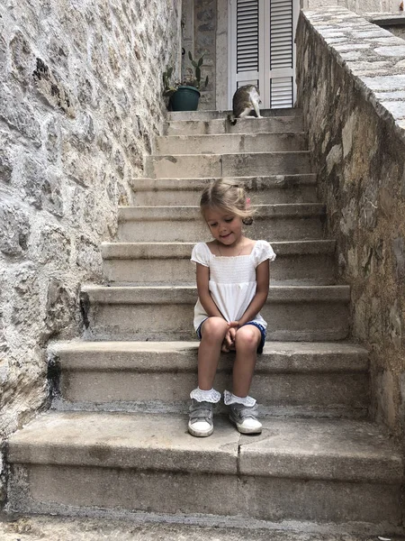Modesta triste bambina seduta sulle scale di pietra nel mediev — Foto Stock