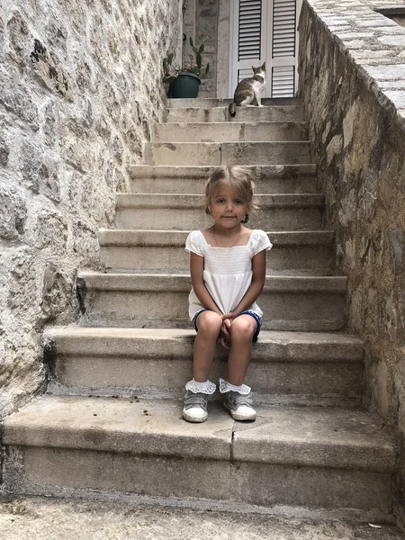 Modesta triste bambina seduta sulle scale di pietra nel mediev — Foto Stock