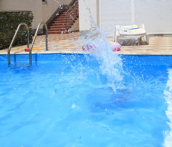 Água espirra após o salto da criança para a piscina — Fotografia de Stock