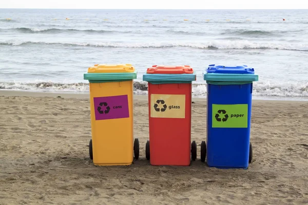 Recipientes multicoloridos para triagem de lixo estão na praia ag — Fotografia de Stock