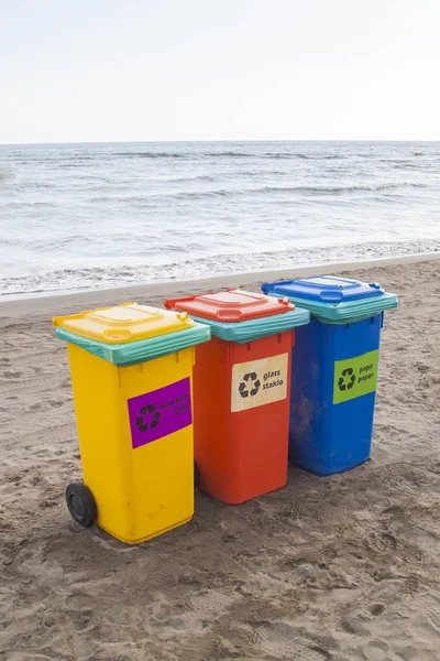 Recipientes multicoloridos para triagem de lixo estão na praia ag — Fotografia de Stock