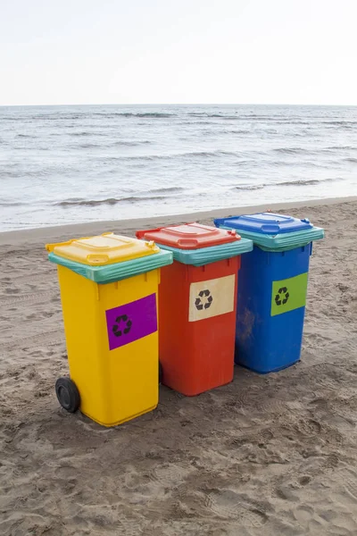 Recipientes multicoloridos para triagem de lixo estão na praia ag — Fotografia de Stock