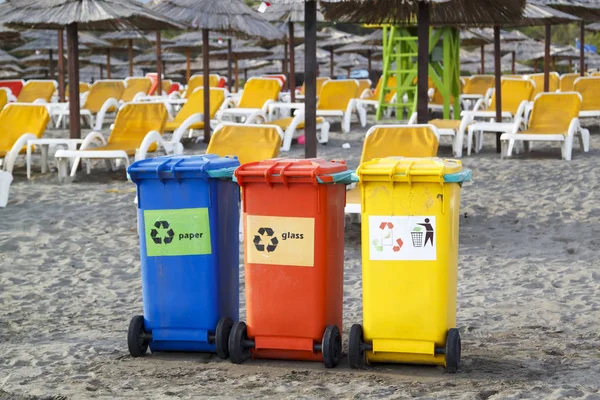 Três caixas de reciclagem coloridas na praia — Fotografia de Stock