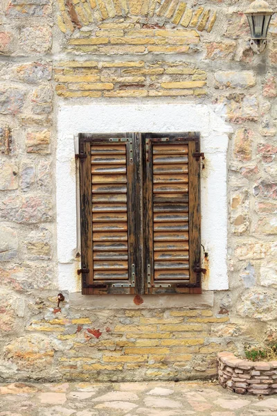 Muro de piedra con persianas de madera cerradas ventana en el casco antiguo de Budva — Foto de Stock