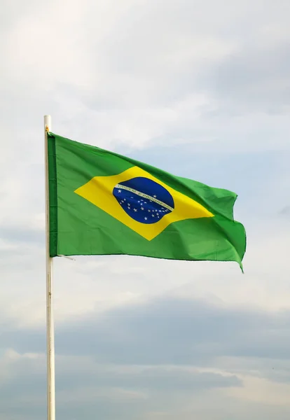 Bandeira brasileira em um céu azul com fundo de nuvens — Fotografia de Stock