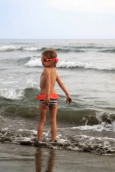 Bambino giocare con le onde splahes del mare — Foto Stock