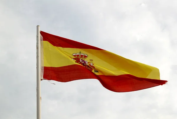 Bandera de España sobre un cielo azul con nubes de fondo — Foto de Stock