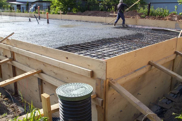 Worker leveling fresh concrete slab with a special wooden workin — Stock Image Worker leveling fresh concrete slab with a special wooden workin Royalty Free Stock Photos