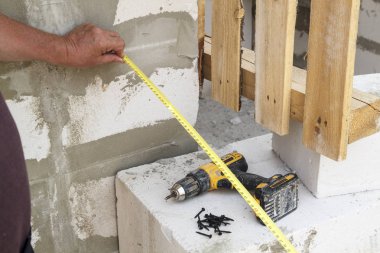 Ölçüm bandını yanında tutan elin yakın görünümünü