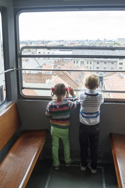 As crianças escalam em um funicular vazio e olham o panorama de — Fotografia de Stock
