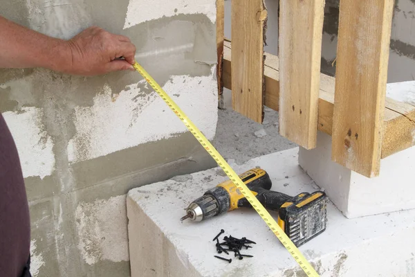 Ölçüm bandını yanında tutan elin yakın görünümünü