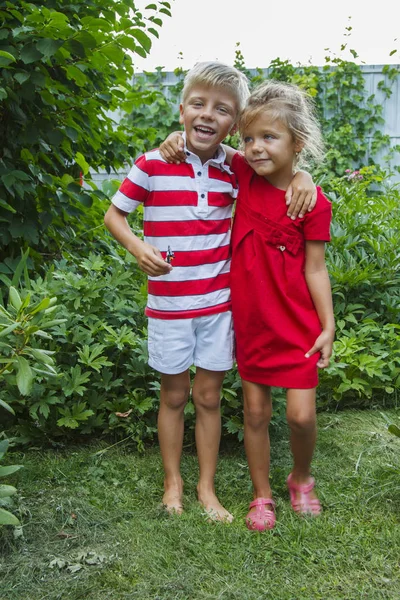 Happy little boy and girl hugging outdoors in summer — Stock Photo, Image