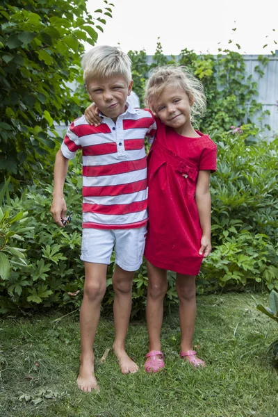 Happy little boy and girl hugging outdoors in summer — Stock Photo, Image