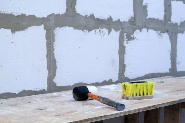 Hammer and brush are on the foam blocks on the construction of a — Stock Photo, Image