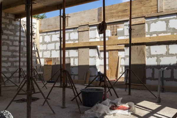 Blick auf die Holzschalung mit Metallhalterungen, die vom Schaumstoffblock aus mit der Überlappung zwischen den Fußböden des im Bau befindlichen Landhauses gefüllt wird — Stockfoto