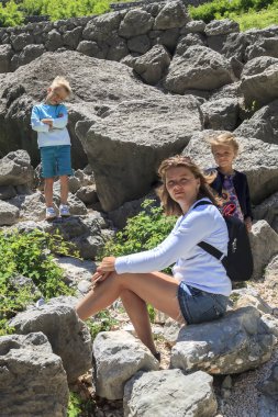 çocuklu güzel kız kamera poz için yamaca oturdu