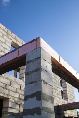İnşaat halindeki bir kır evinin içinde. Duvarların üzerine gaz, beton bloklar ve ahşap işlemelerle inşa edildiği alan.