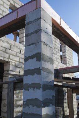 İnşaat halindeki bir kır evinin içinde. Duvarların üzerine gaz, beton bloklar ve ahşap işlemelerle inşa edildiği alan.