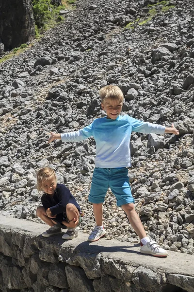 Bambina seduta su un fianco della montagna non lontano sopra è serena suo fratello — Foto Stock