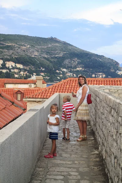 Conceito de recreação cognitiva com crianças. mãe viajante, filha e filho nas paredes que encerram a cidade velha de Dubrovnik no por do sol — Fotografia de Stock
