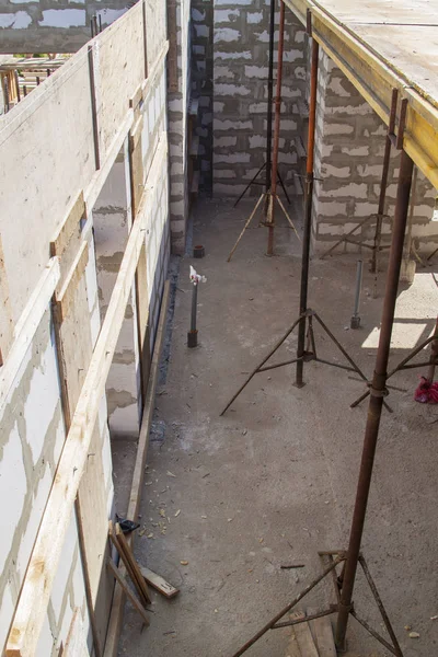 Blick auf die Holzschalung mit Metallhalterungen, die vom Schaumstoffblock aus mit der Überlappung zwischen den Fußböden des im Bau befindlichen Landhauses gefüllt wird — Stockfoto