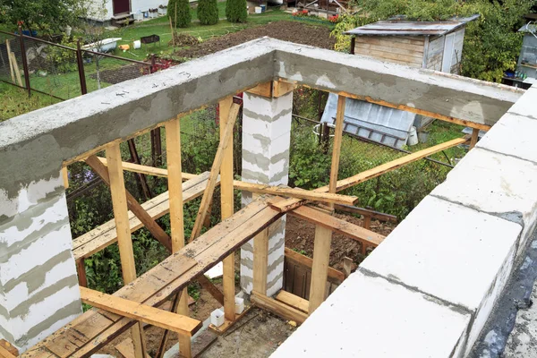 View of pit dug under foundation for a barbecue in annex to house. Site on which the walls are built of gas concrete blocks with wooden formwork — Stock Photo, Image