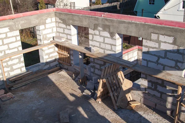 Interior de una casa de campo en construcción. Sitio en el que se construyen las paredes de bloques de hormigón de gas con encofrado de madera — Foto de Stock