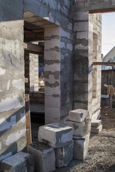 İnşaat halindeki bir kır evinin içinde. Duvarların üzerine gaz, beton bloklar ve ahşap işlemelerle inşa edildiği alan.