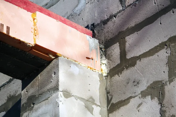 Close-up weergave van het docking betonnen balk met een houten log aan de schuim blok muur van een landelijk huisje in aanbouw — Stockfoto