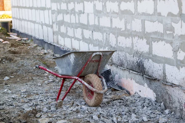 Site de construction sur lequel les murs sont construits de blocs de béton gazeux et brouette — Photo