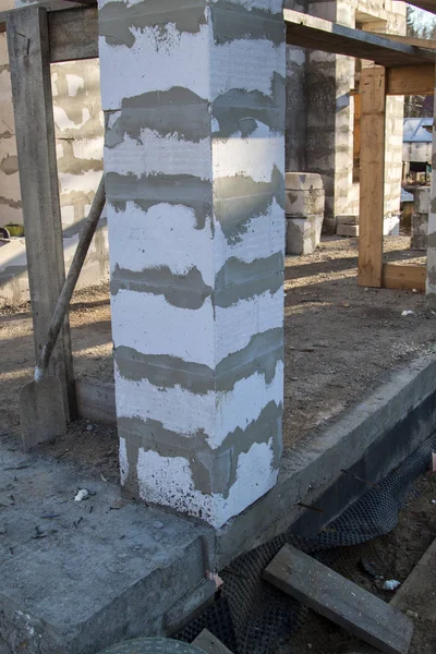 İnşaat halindeki bir kır evinin içinde. Duvarların üzerine gaz, beton bloklar ve ahşap işlemelerle inşa edildiği alan.