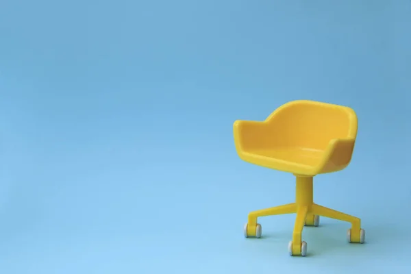 Boş sandalye kavramı. Mavi temiz arka plan üzerinde sarı dışkı. En az tarzda fotoğraf. — Stok fotoğraf