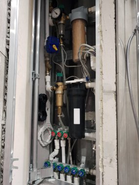 Filtreler, paslanmaz top valfleri, su detektörü ve merkezi ısıtma sisteminin plastik boruları.