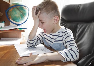 Ödev yaparken ağlayan ve çığlık atan okul çağındaki bir çocuk. Ko