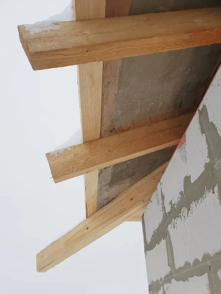 Nahaufnahme der Hausecke mit Baugerüst, wo vorbereitende Arbeiten durchgeführt werden, bevor das endgültige Dach abgedeckt wird — Stockfoto