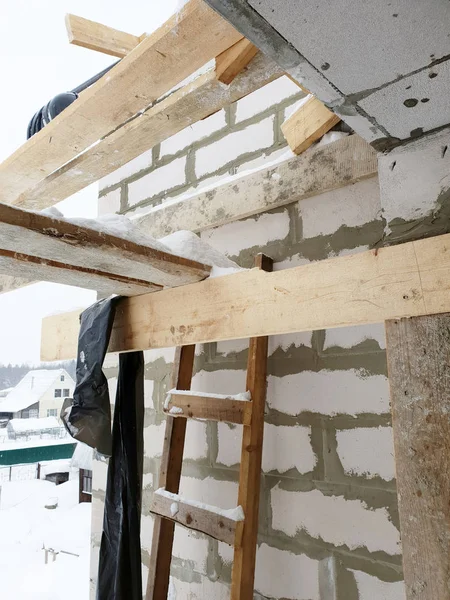 Nahaufnahme der Hausecke mit Baugerüst, wo vorbereitende Arbeiten durchgeführt werden, bevor das endgültige Dach abgedeckt wird — Stockfoto