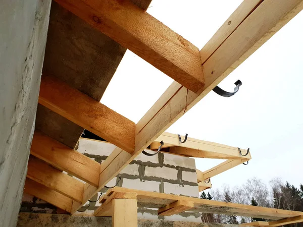 Primer plano vista de andamios y casa en construcción con soportes para canaletas sistema de drenaje de agua de techo — Foto de Stock