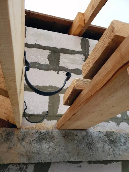 Vista de primer plano de la esquina de la casa con andamios, donde se llevan a cabo los trabajos preparatorios antes de cubrir el techo del techo final — Foto de Stock