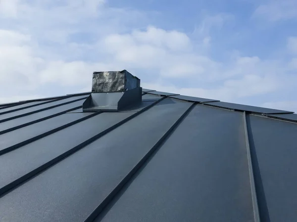 Close up view of grey folding roof and chimney on waterproofing layer of house under construction — Stock Photo, Image