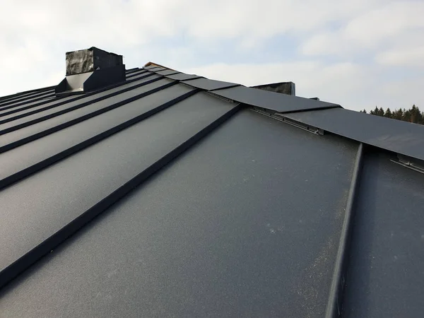 Close up view of grey folding roof and chimney on waterproofing layer of house under construction — Stock Photo, Image