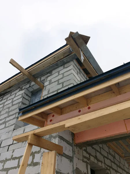 Vista de cerca de andamios y casa en construcción con techo plegable gris sobre capa de impermeabilización —  Fotos de Stock