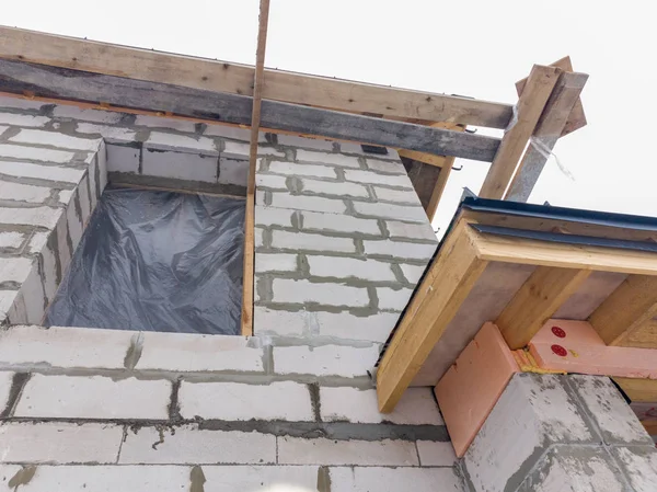 Z bliska widok rusztowania i domu w budowie z szarym dachem składanym na warstwie hydroizolacyjnej — Zdjęcie stockowe