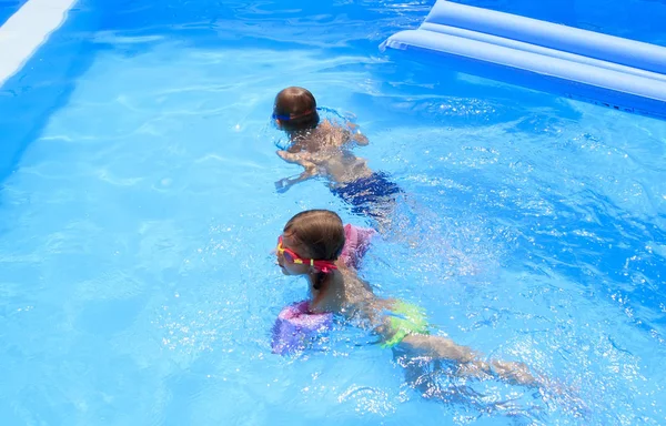 Chłopiec i dziewczynka pływacki w basenie w willi — Zdjęcie stockowe