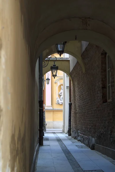 Narrow street with lamps to the St. Martin's Church architectural details in Warsaw Old Town — ストック写真